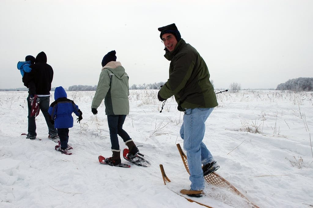 Family snowshoeing across an open snow field